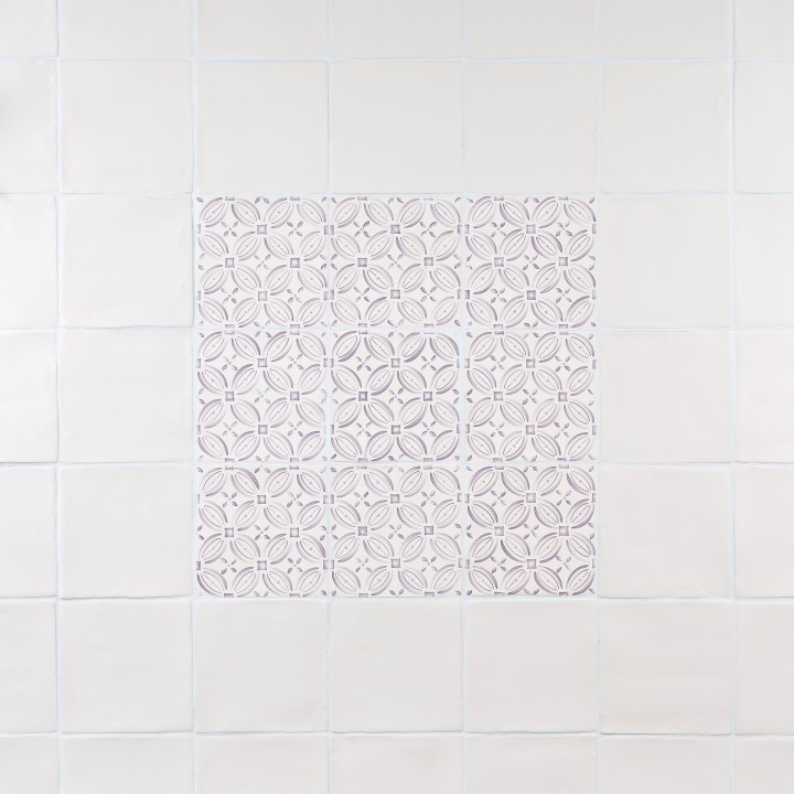 Wall of ivory square tiles framing a 9 pink pattern tiles