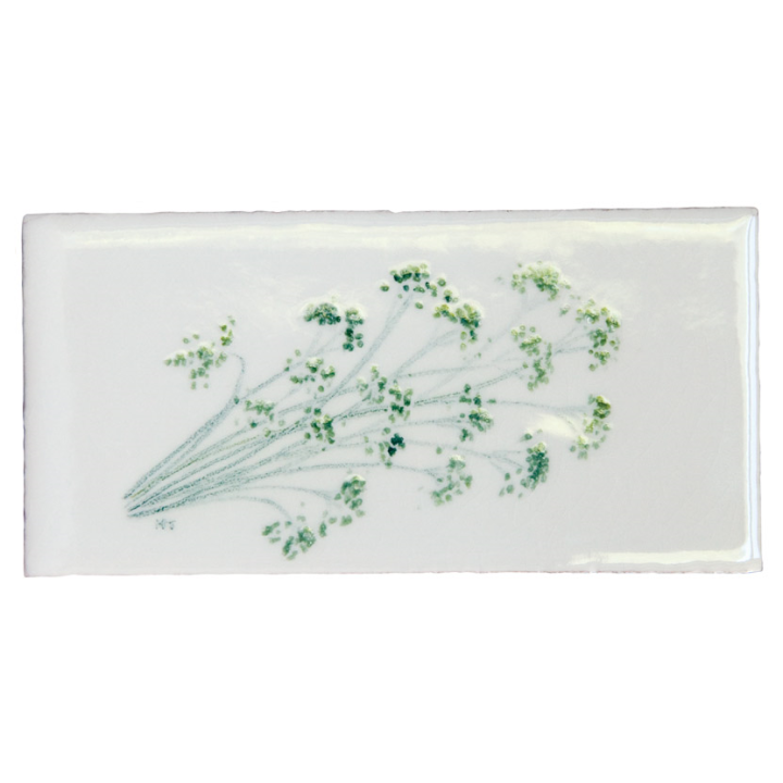 Cut out of a parsley sprig on an off white metro tile