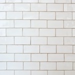 Wall of soft white metro brick tiles with beige grout