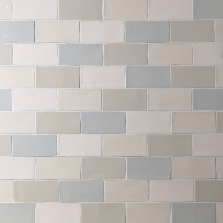 Wall of a mixture of medium brick metro tiles in blues, greys and off-whites