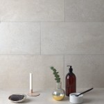 Wall of pale limestone effect rectangle porcelain tiles laid on a bathroom wall and floor