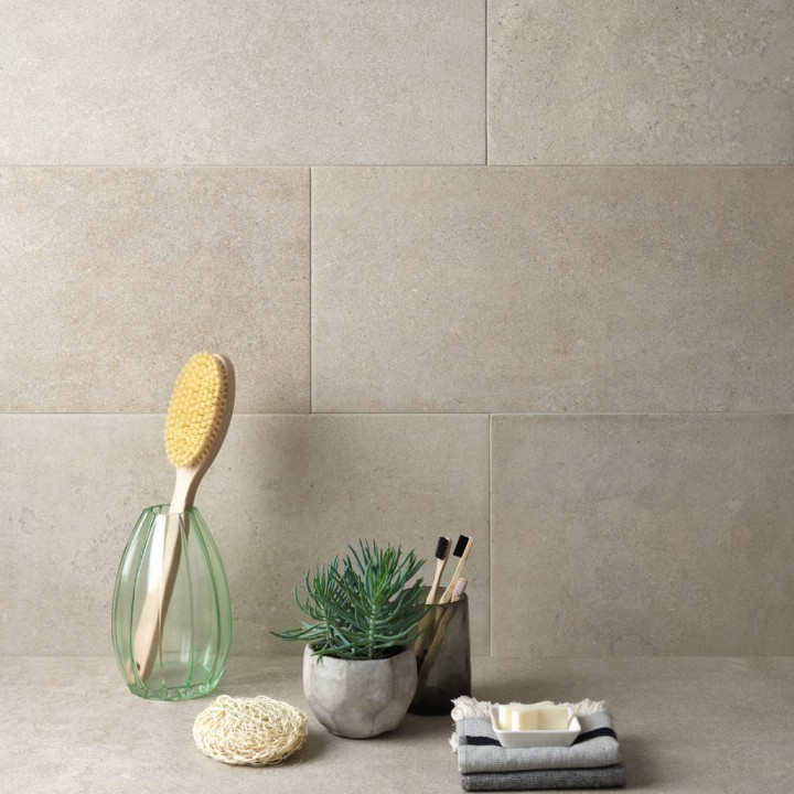 Wall of bath stone effect rectangle porcelain tiles featuring in a bathroom behind bathroom accessories