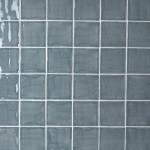 Wall of square grey blue handmade wall tiles finished with White grout