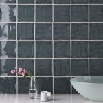 Wall of square dark grey handmade wall tiles behind a marble work top and a large bowl, espresso cup and vase