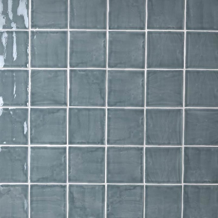 Wall of square grey blue handmade wall tiles finished with White grout