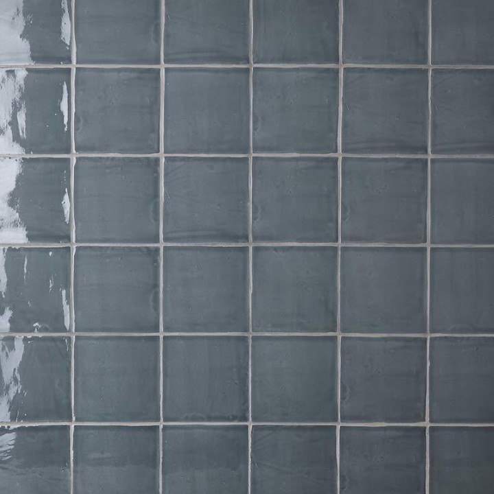 Wall of square dark grey blue handmade wall tiles finished with Silver Grey grout
