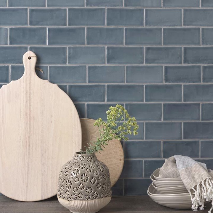 Wall of metro dark grey blue handmade wall tiles behind a grey wood work top and chopping boards