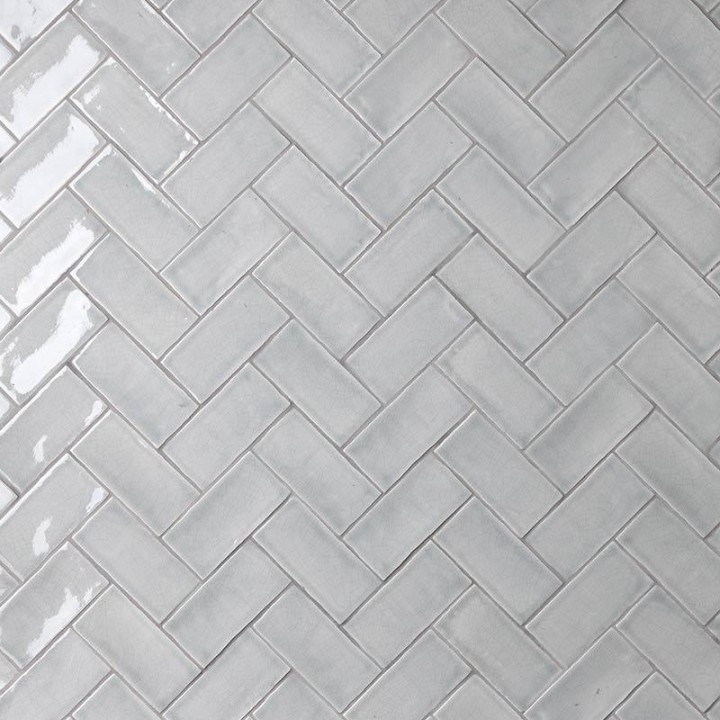 Wall of metro grey handmade wall tiles laid in a herringbone tile pattern finished with Medium Grey grout