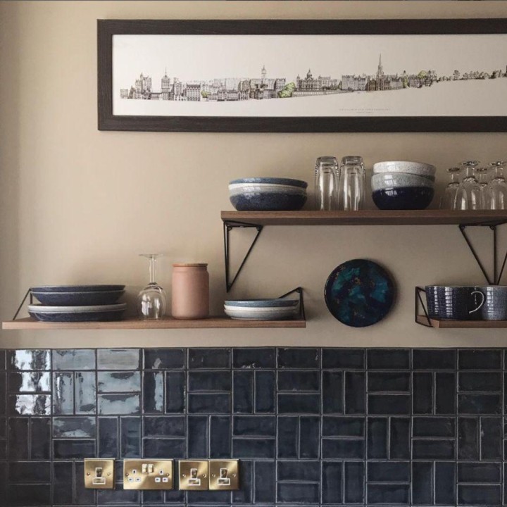 Dark navy blue small brick shaped wall tiles in a basket weave pattern on a kitchen wall