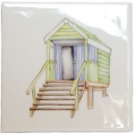 A cut out of an antique white square tile with beach hut illustration