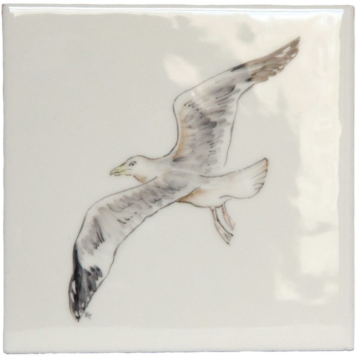 A cut out of an antique white square tile with seagull illustration