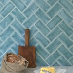 Wall of gloss bright blue green medium metro tile laid in a herringbone tile pattern behind kitchenware