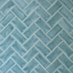 Wall of gloss bright blue medium metro tile laid in a herringbone tile pattern