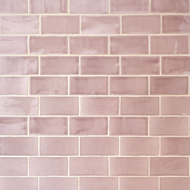 Wall of gloss dusky rose pink medium metro tile laid in a brick bond tile pattern behind