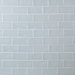 Wall of pale blue medium brick metro tiles with silver grey grout laid in a brick bond tile pattern