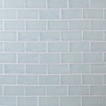 Wall of pale blue medium brick metro tiles with silver grey grout laid in a brick bond tile pattern