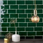 Wall of emerald green medium brick metro tiles with white grout against a grey oak worktop with home accessories on top