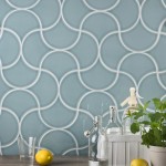Wall of cool green scallop tiles with white grout against an oak porcelain floor behind kitchen accessories