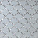 Wall of pale silver blue scallop tiles with medium grey grout laid in a fish scale pattern ideal for kitchens and bathrooms