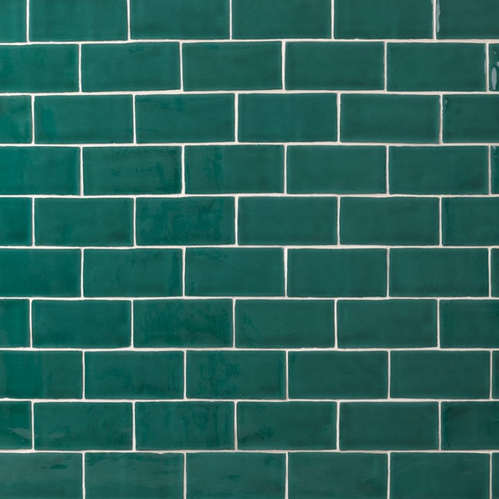 Wall of bottle green medium brick metro tiles with white grout laid in a brick bond tile pattern