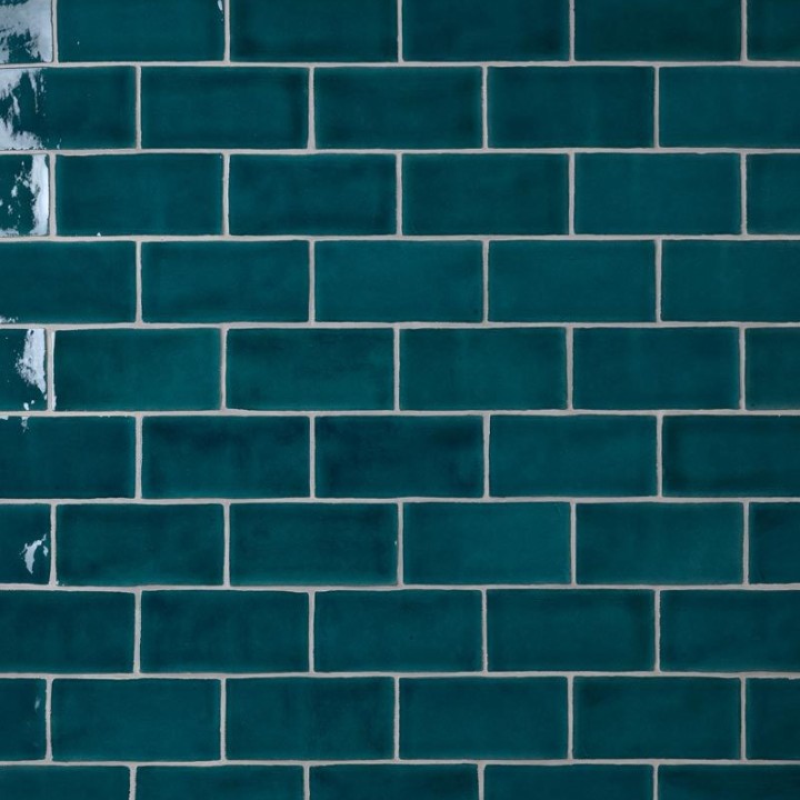 Wall of sapphire navy blue medium brick metro tiles with white grout laid in a brick bond tile pattern