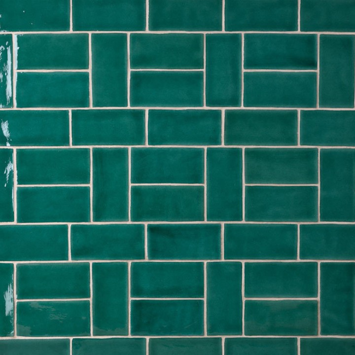 Wall of emerald green medium brick metro tiles with white grout