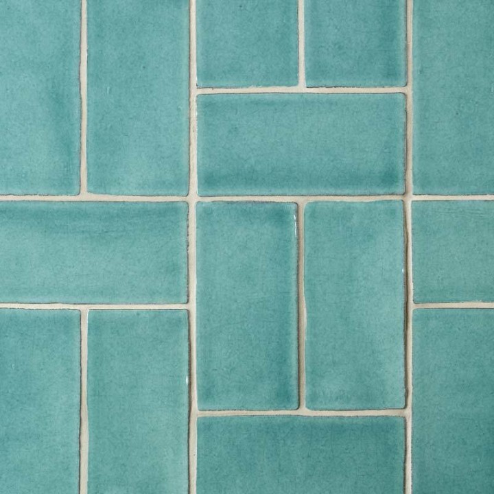Close up of 14 aqua green medium brick metro tiles with beige grout