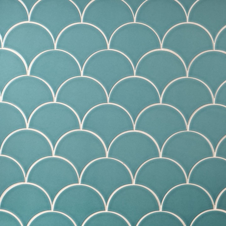 Wall of aqua green scallop tiles with white grout laid in a fish scale pattern ideal for kitchens and bathrooms