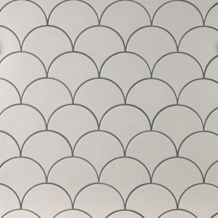 Wall of warm white scallop tiles with medium grey grout laid in a fish scale pattern ideal for kitchens and bathrooms
