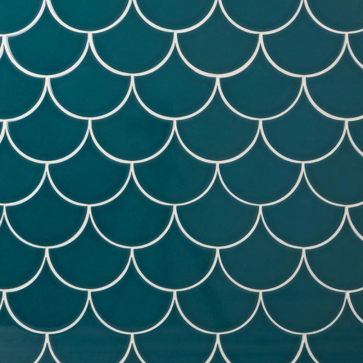 Wall of sapphire blue scallop tiles with white grout laid in a fish scale pattern ideal for kitchens and bathrooms