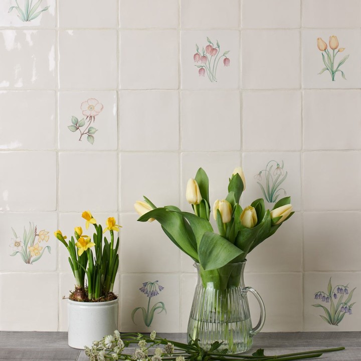 Wall of spring flower square tiles featuring hand painted bulbs like daffodils, tulips and snowdrops with daffodils in the foreground