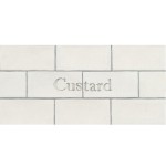 Cut out of two word metro tiles with the word 'custard' hand painted on them