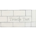 Cut out of two word metro tiles with the word 'Treacle Tart' hand painted on them