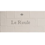 Cut out of two word metro tiles with the word 'Le Roule' hand painted on them