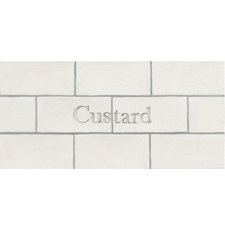 Cut out of two word metro tiles with the word 'custard' hand painted on them