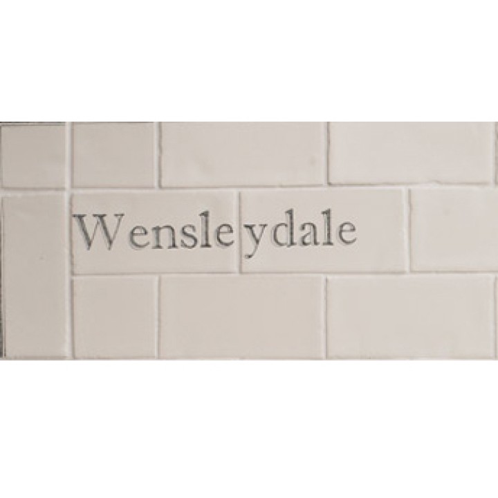 Cut out of two word metro tiles with the word 'Wensleydale' hand painted on them