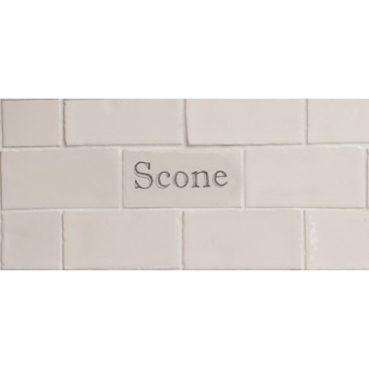 Cut out of one word metro tiles with the word 'scone' handpainted on them