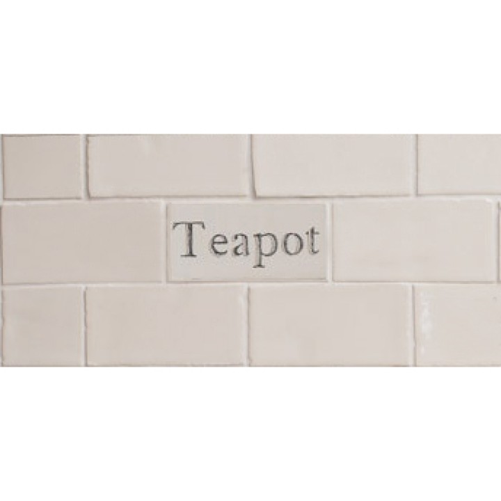 Cut out of one word metro tile with the word 'teapot' hand painted on them