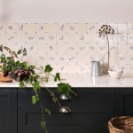 Wall of delft wilding tiles featuring several animal illustrations above navy kitchen cupboards