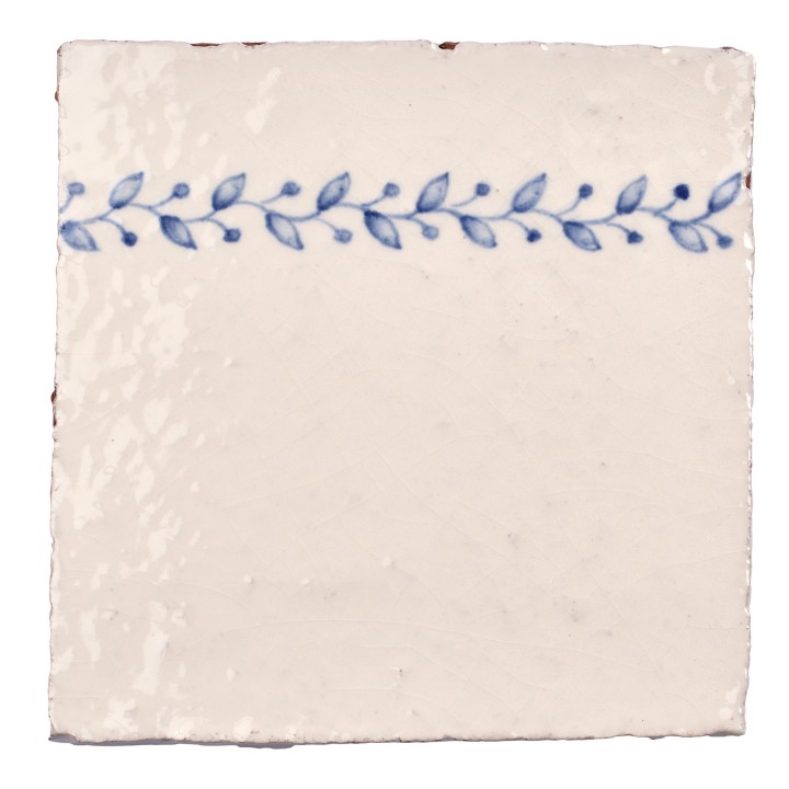 Cut out image of white tile with handpainted delft blue order ornate pattern