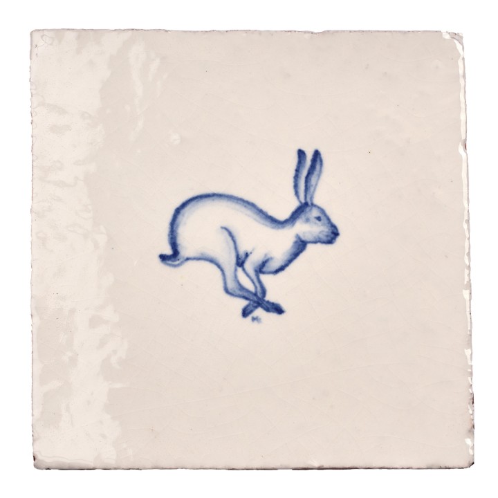 Cut out image of white tile with handpainted delft blue hare illustration