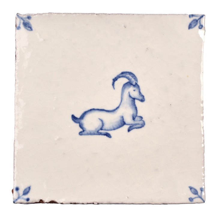 Cut out image of white tile with handpainted delft ibex illustration and ornate corners