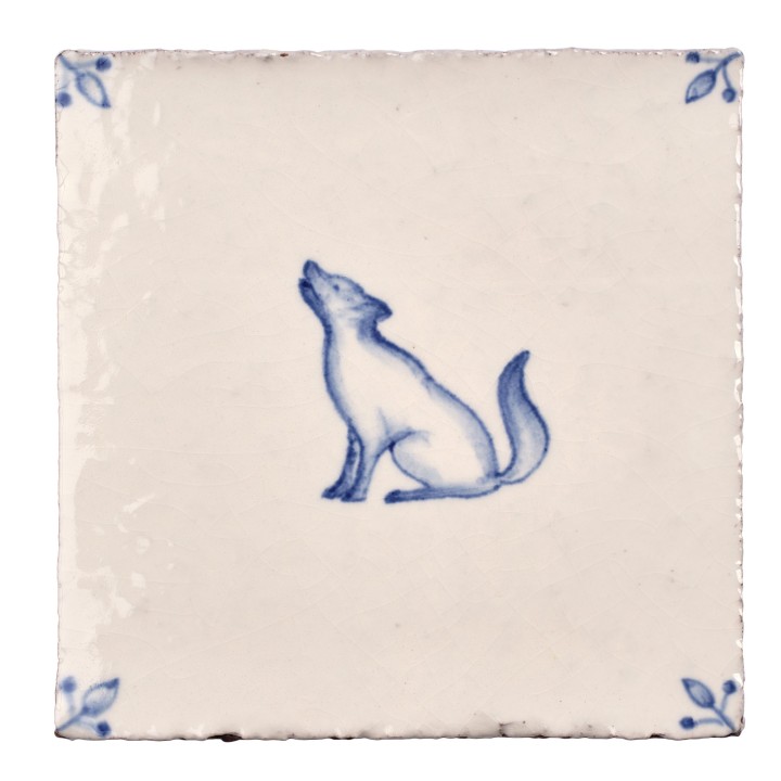 Cut out image of white tile with handpainted delft wolf illustration and ornate corners