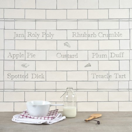 Tiled splashback with names of british puddings and illustrations of cakes and swiss rolls