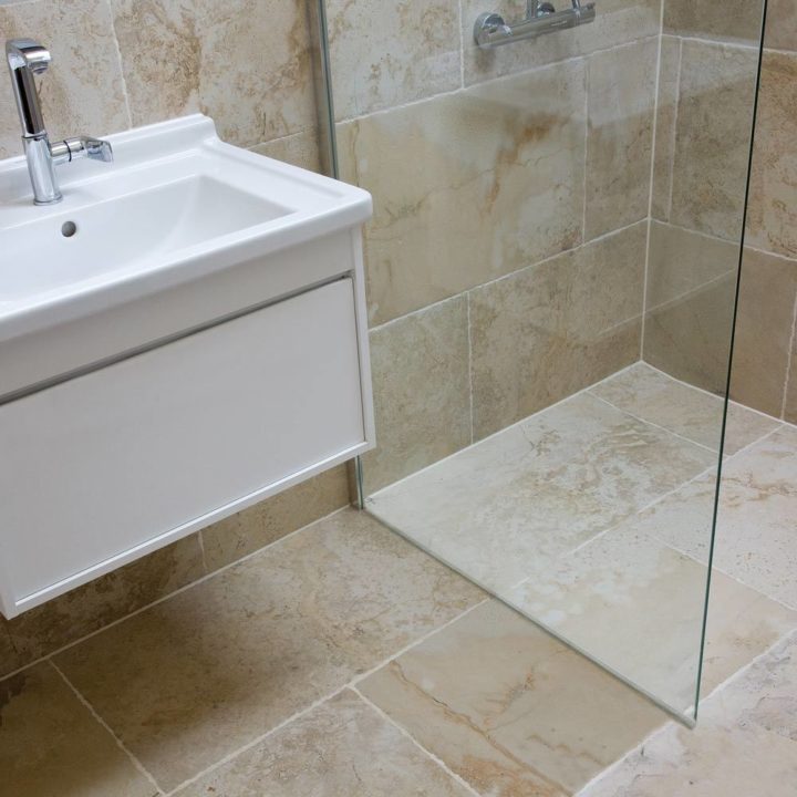 Wet room shower and sink with york stone effect porcelain wall and floor tiles