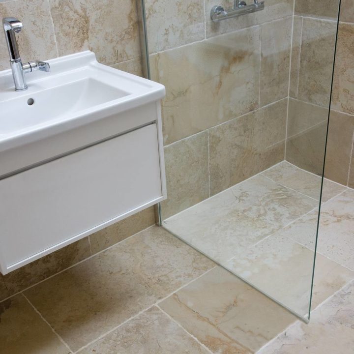 Wet room shower and sink with york stone effect porcelain wall and floor tiles