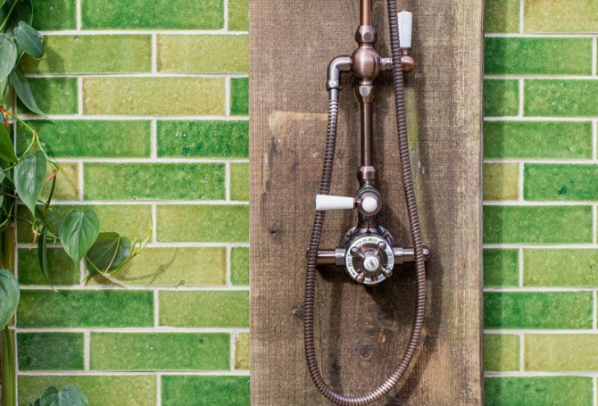 Vibrant green zellige and bejmat effect wall tiles in an outdoor shower