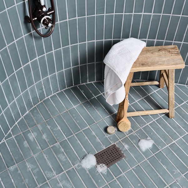 Blue green skinny metro brick tiles in a shower