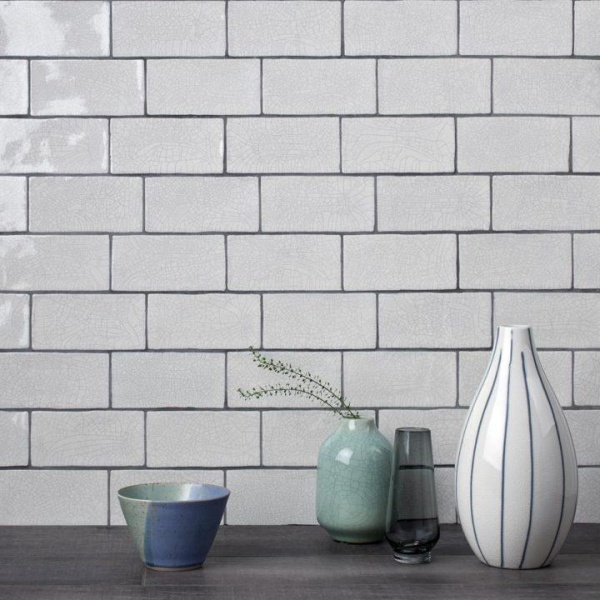 A sideboard with vases and aged crackle medium brick tiles