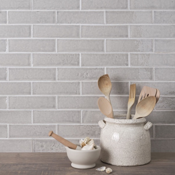 A kitchen sideboard with soft grey skinny metro tiles